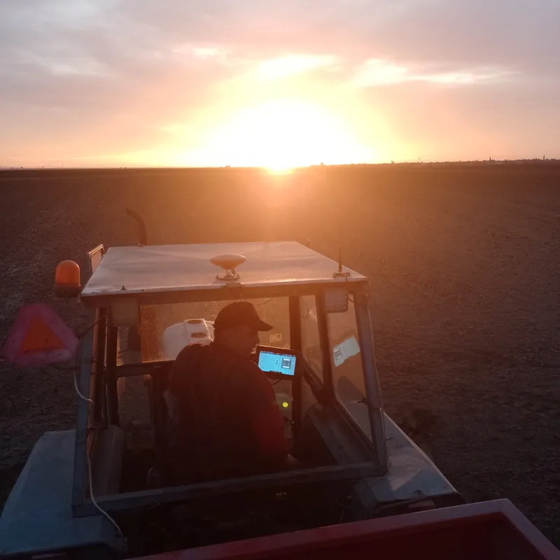 Traktor na njivi u zalazak sunca